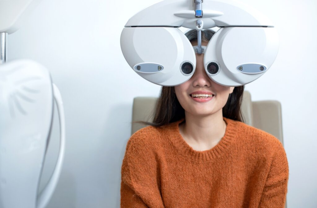 A patient looks through the phoropter during her routine eye exam.