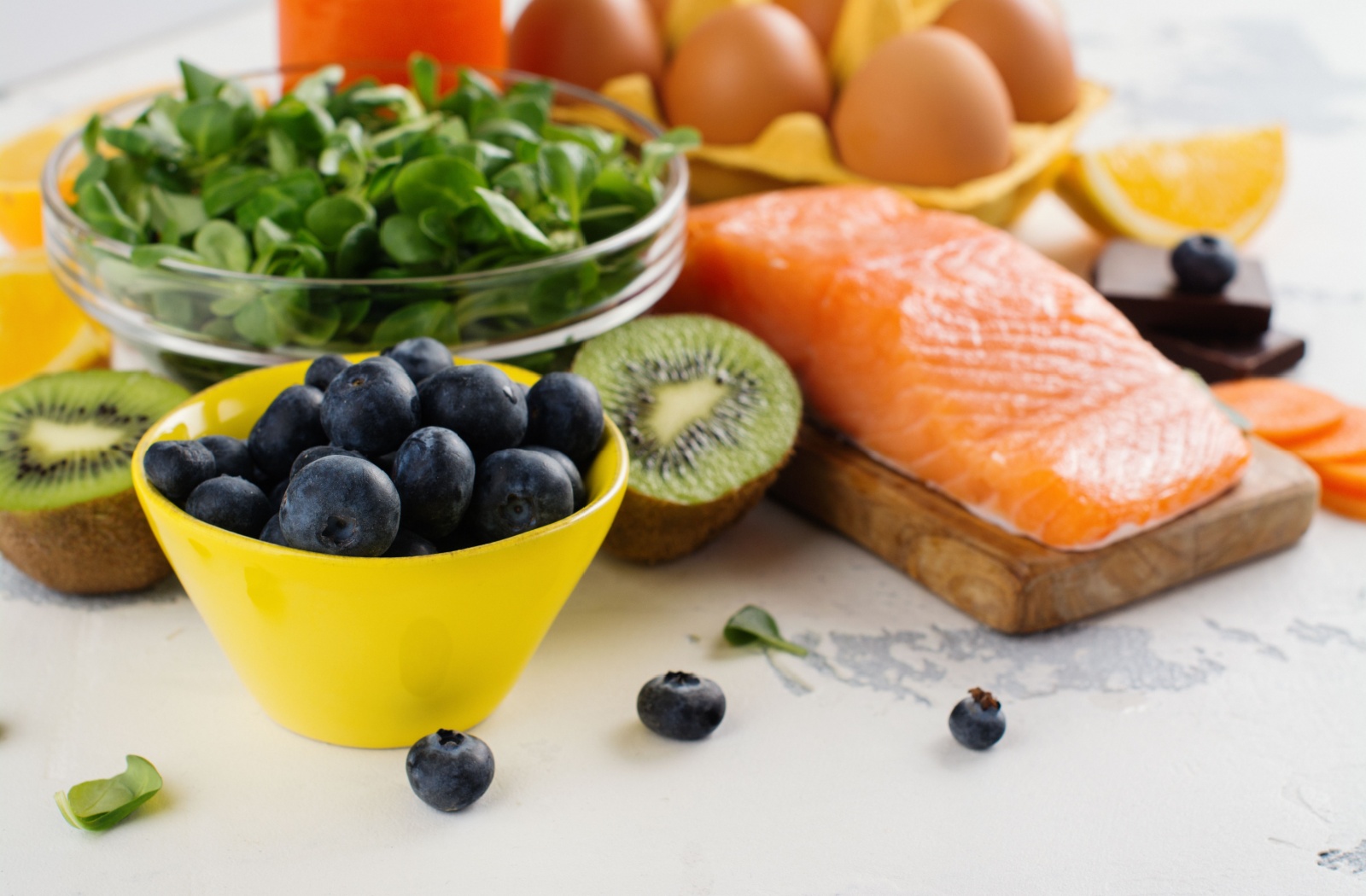 A selection of fruits, vegetables, and fish containing vitamins and minerals important for eye health.