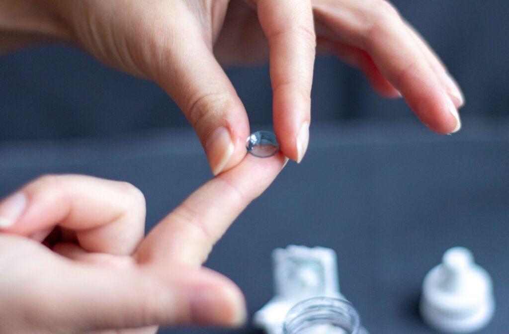 Close up of a person putting a single ortho-k contact lens onto the pad of their finger.