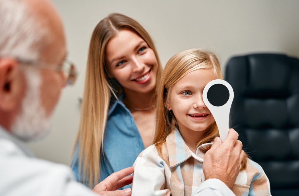 A young patient covers one eye for their visual acuity assessment.