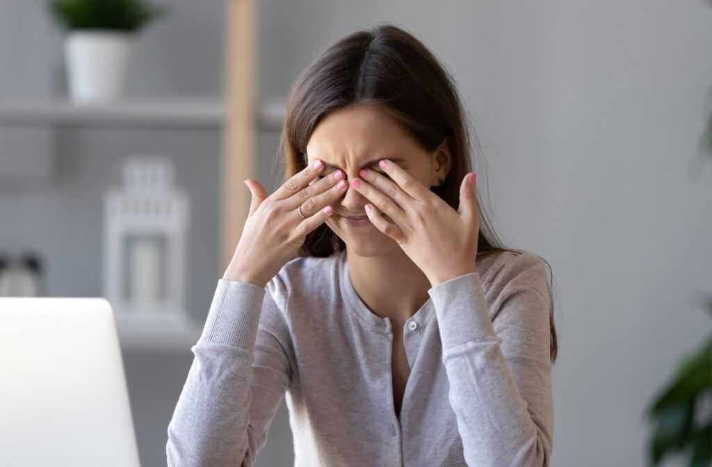 Person rubbing their dry eyes with both hands.
