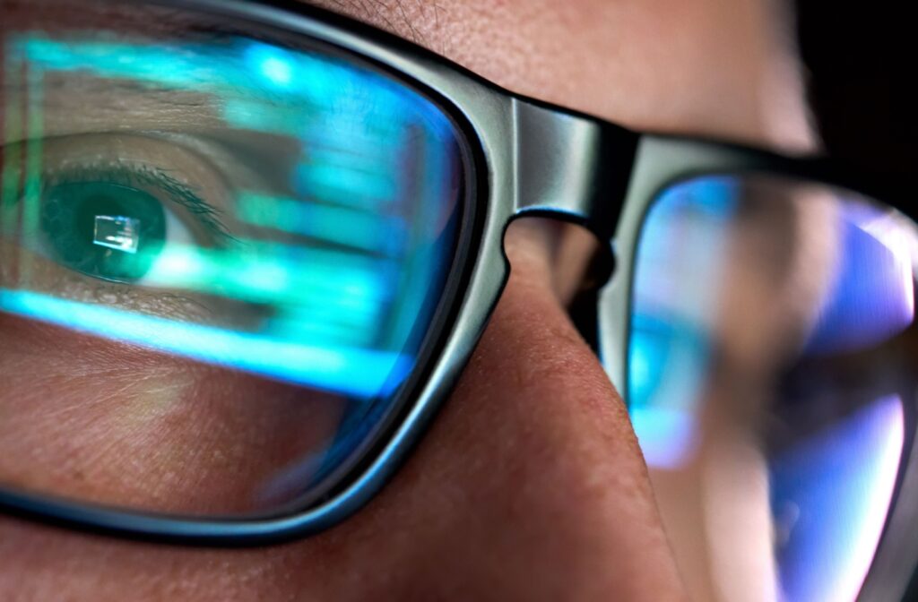 Close up of glasses with a computer reflected in the lenses.