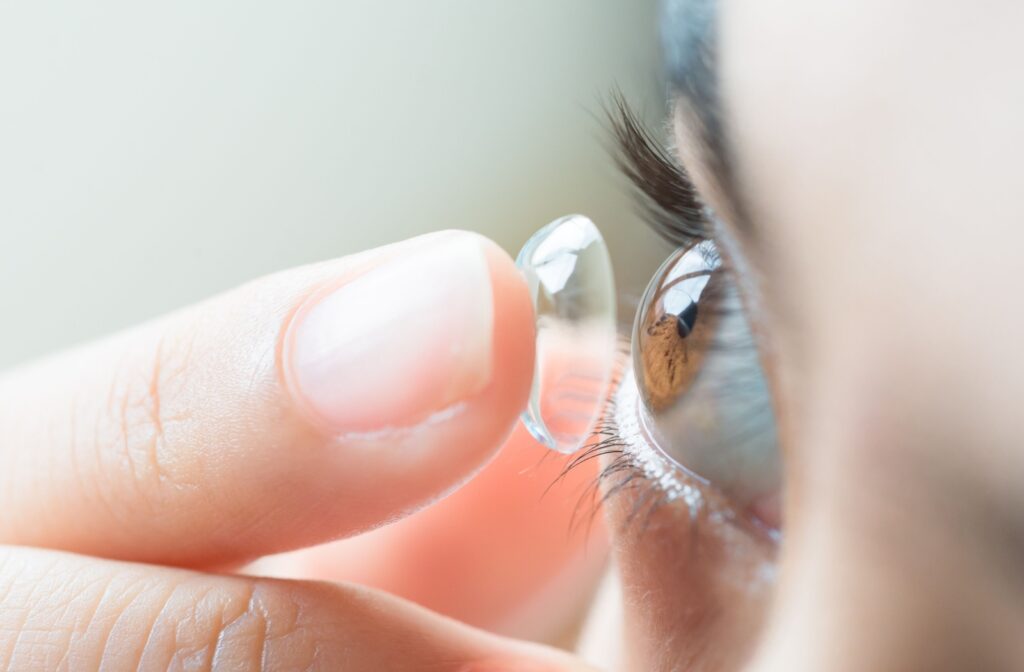A close up of a contact lens being put into an eye