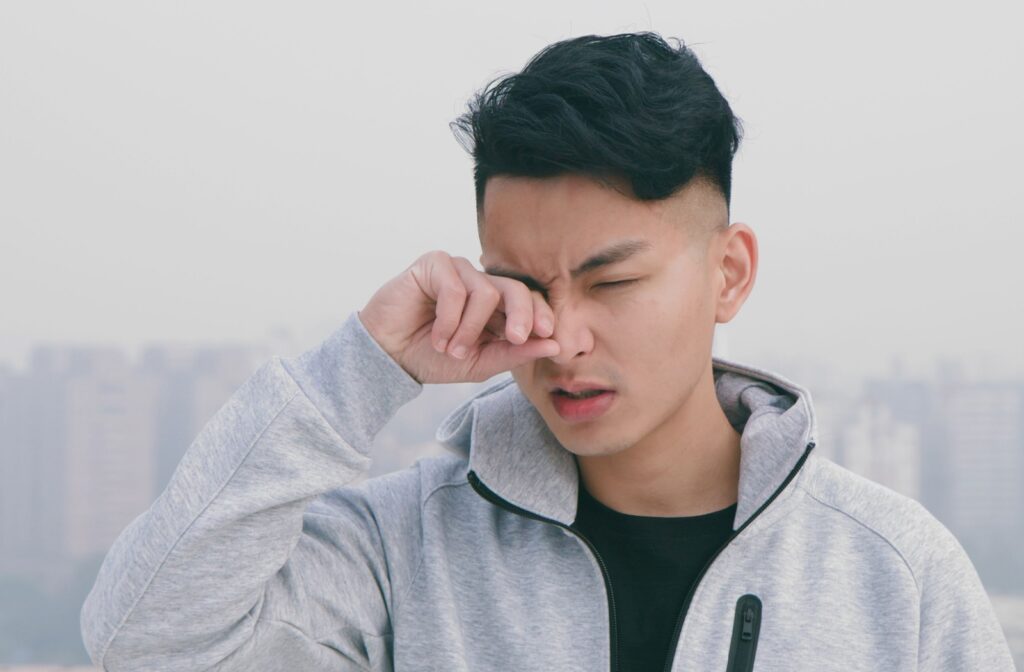 A person who's on a run is rubbing their eyes