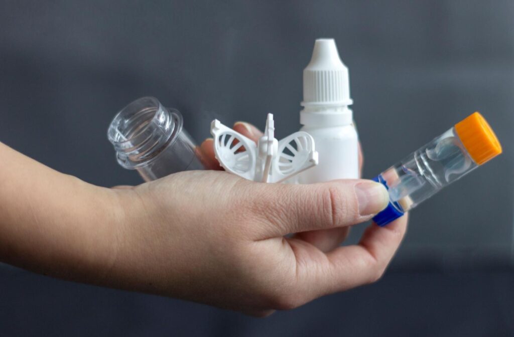 A person holding various ortho-k supplies in their hand
